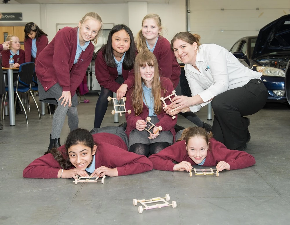 Photo 1: Students from Corpus Christi primary school with automotive tutor and STEM ambassador Katy Malia 