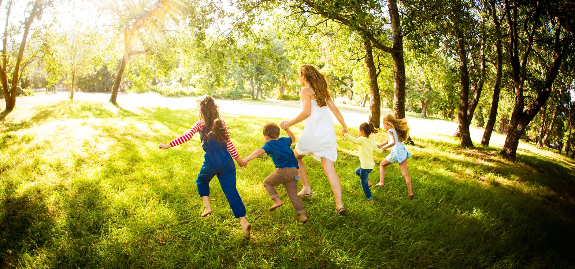 Family hand-in-hand running in the park