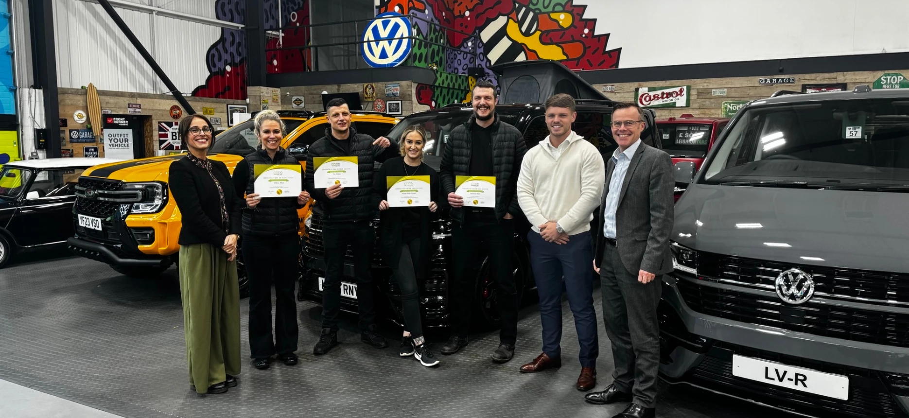 Leighton Vans sales team smiling in front of bespoke VW sports vans