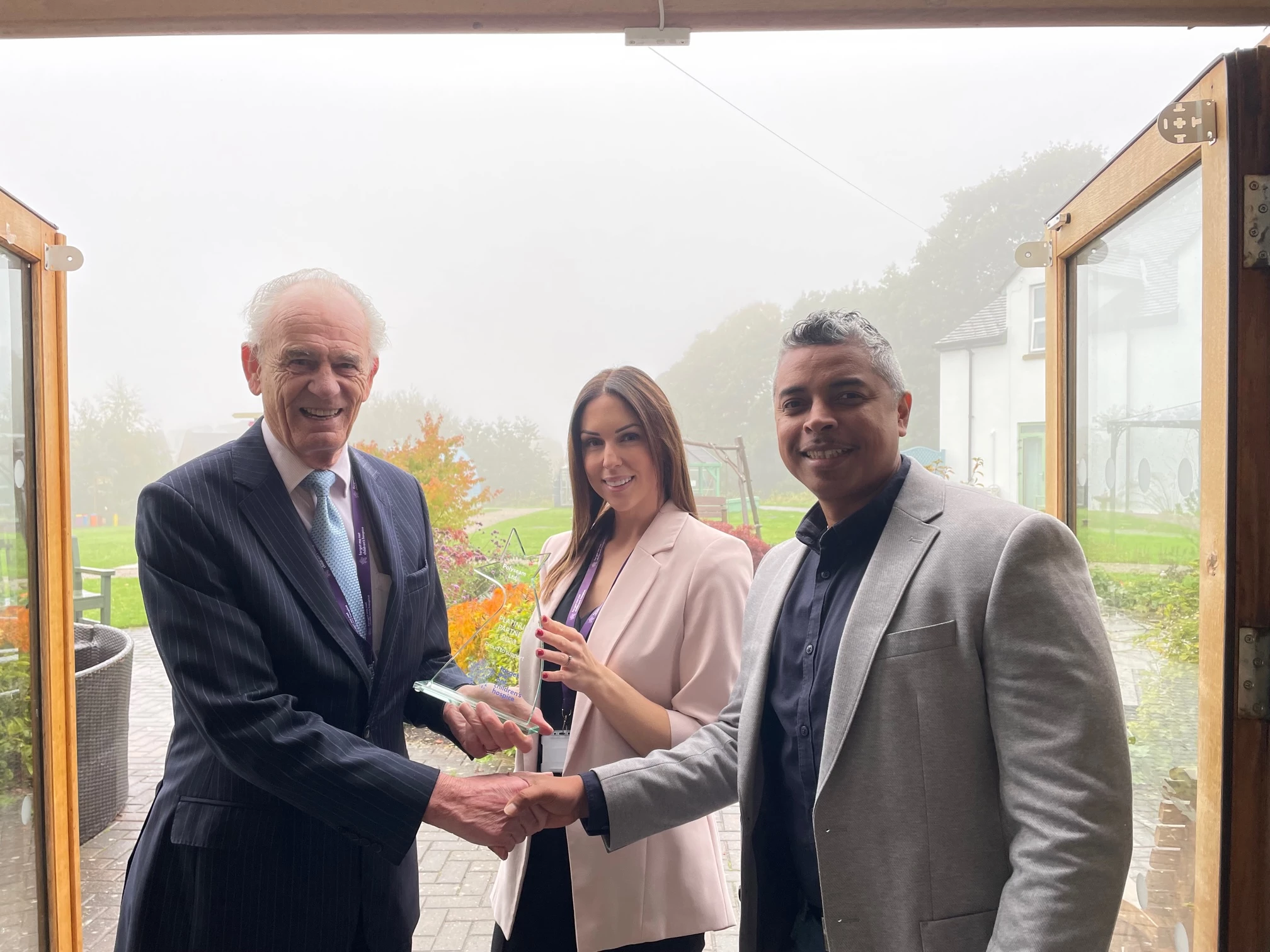 Ken Davy presenting Platinum Partner plaque to Catherine McAliskey, Service Director and Olando Salina, Head of Marketing at Polyseam Ltd