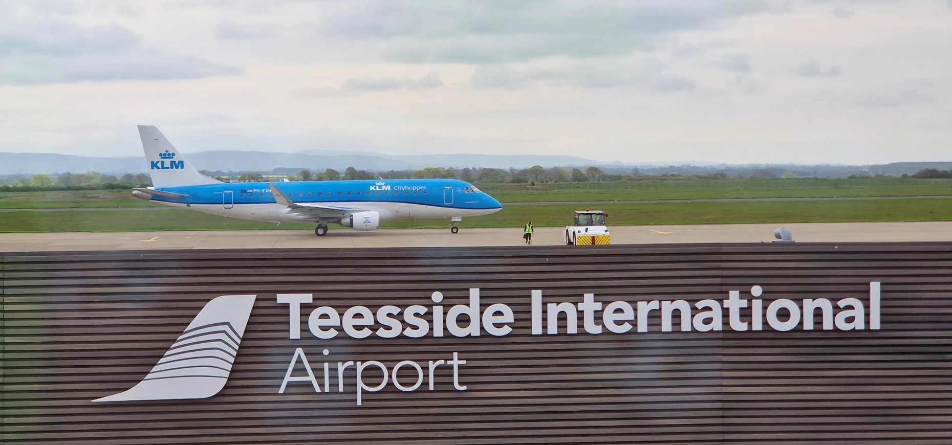 A KLM-branded plane takes off from a runway at Teesside International Airport.