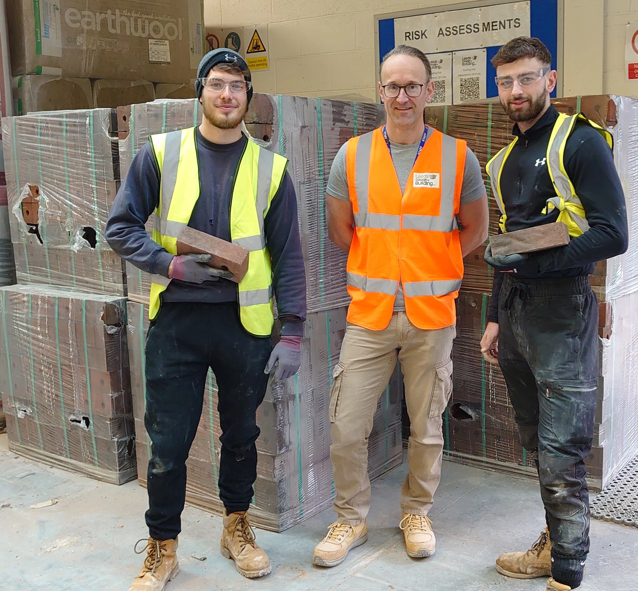 Tutor Steve Roberts (centre) with students and bricks in the brickyard at Leeds College of Building.