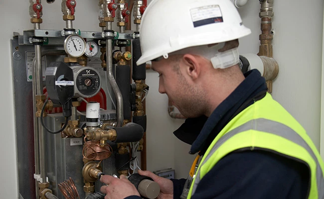 A Vital Engineer installing a Hydraulic Interface Unit (HIU) at one of their projects