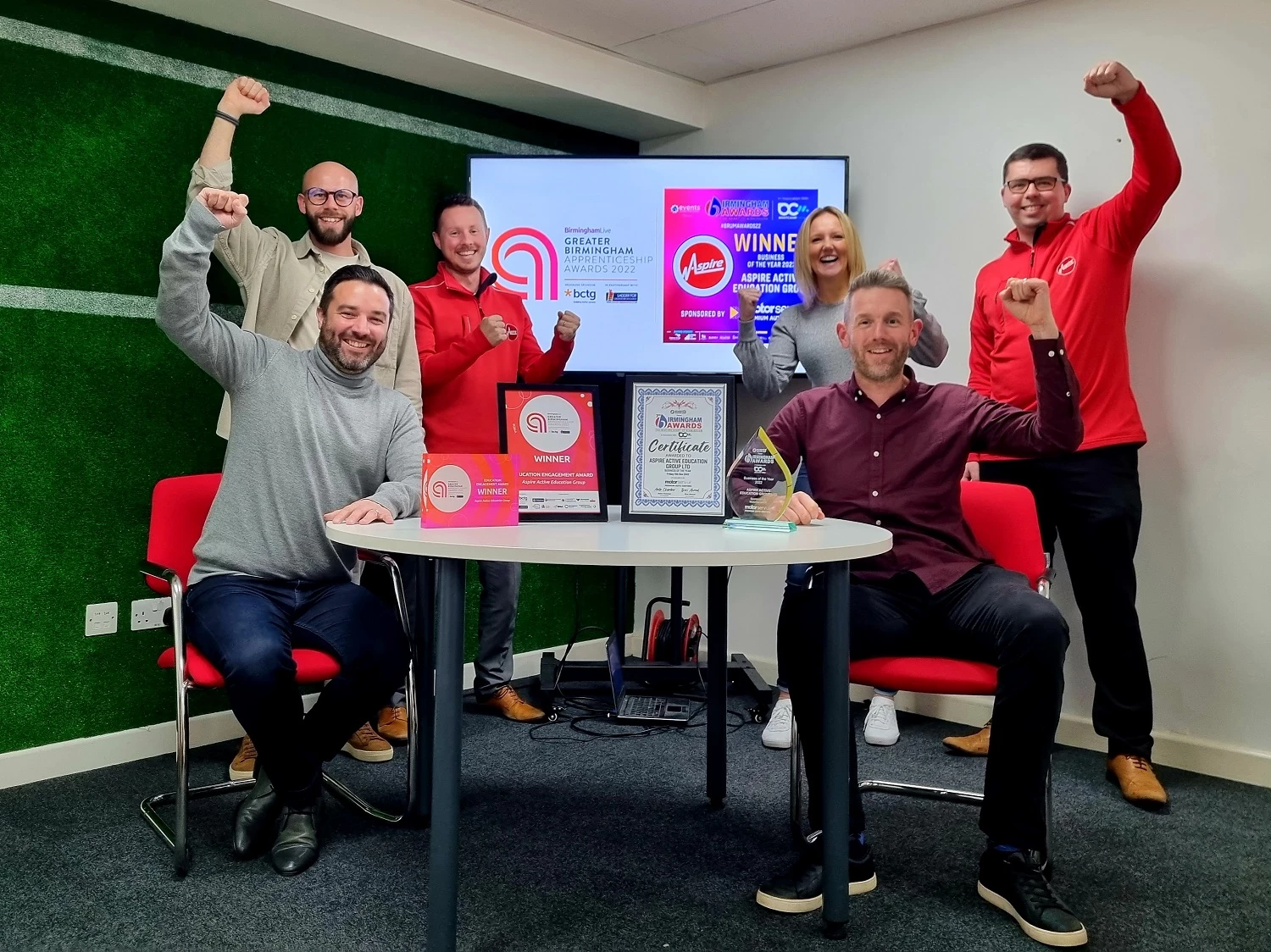 Front seated, from left, Aspire founders James Trowman and Paul Griffiths celebrate the November double award win