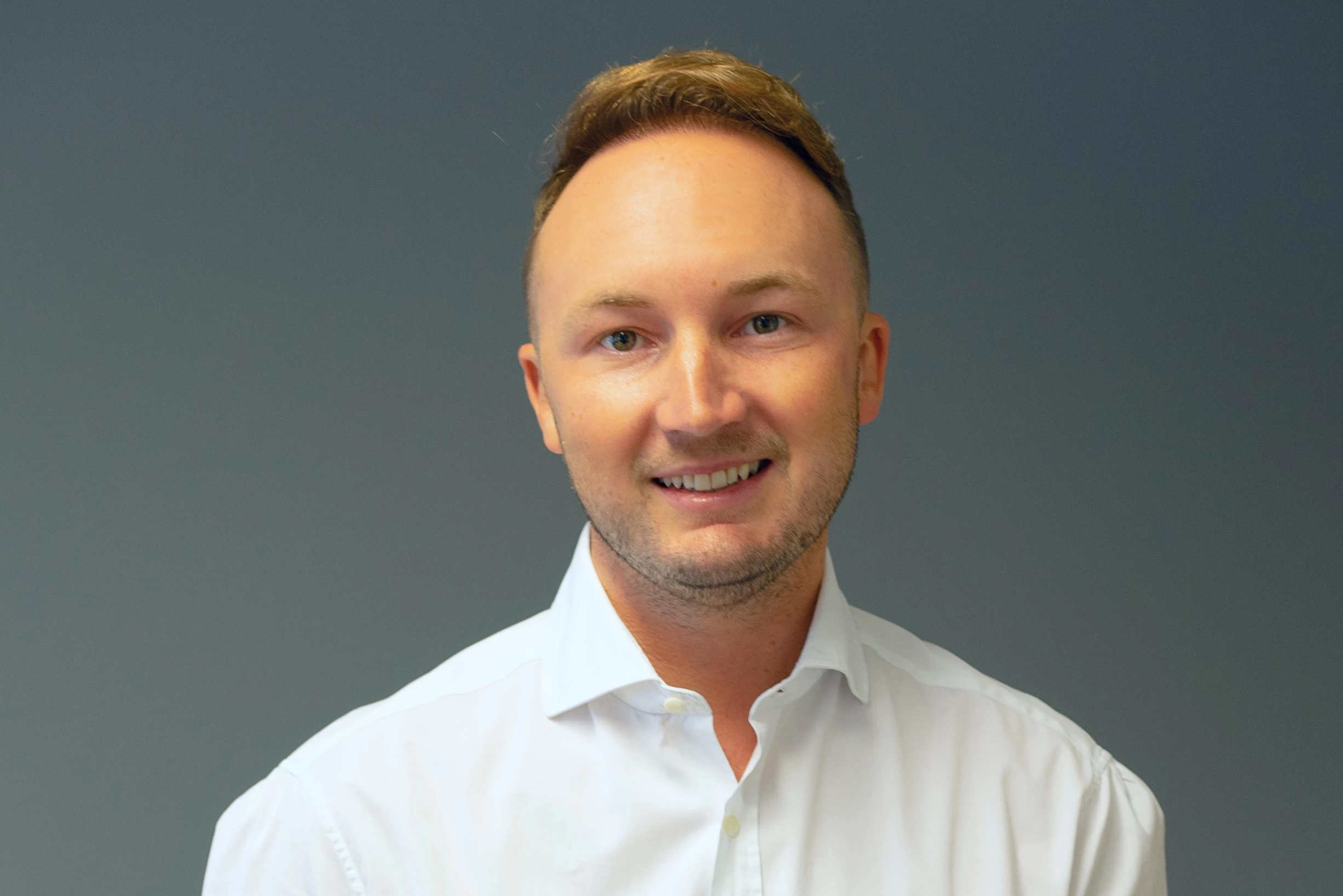 A colour headshot against a plain dark background of British serial entrepreneur and investor, David Newns