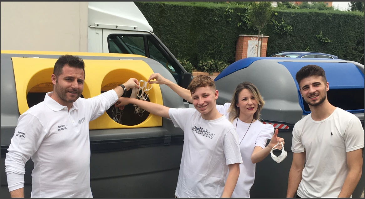 Family recycling at yellow bin in Spain