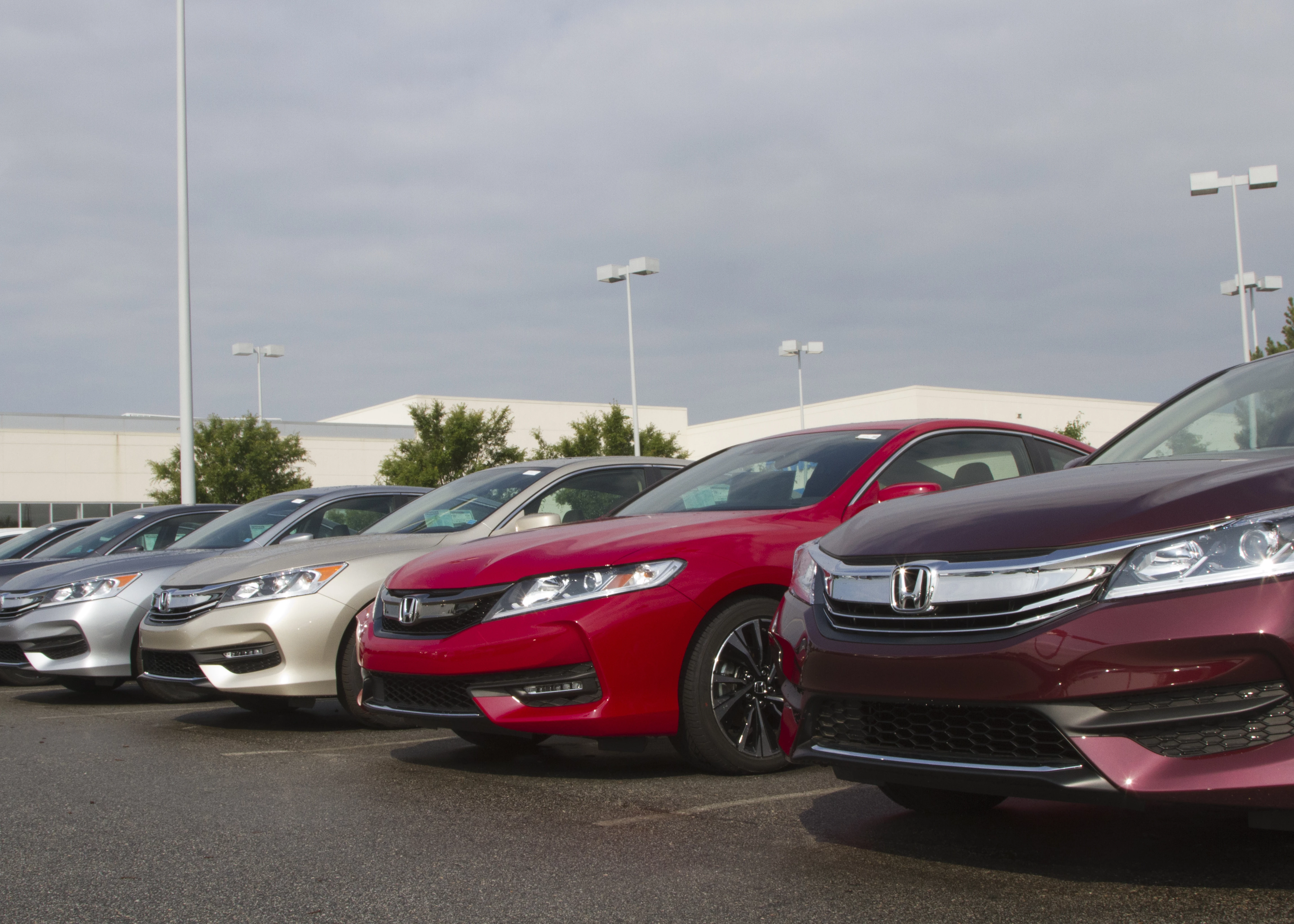 a row of new sedans at a car dealership