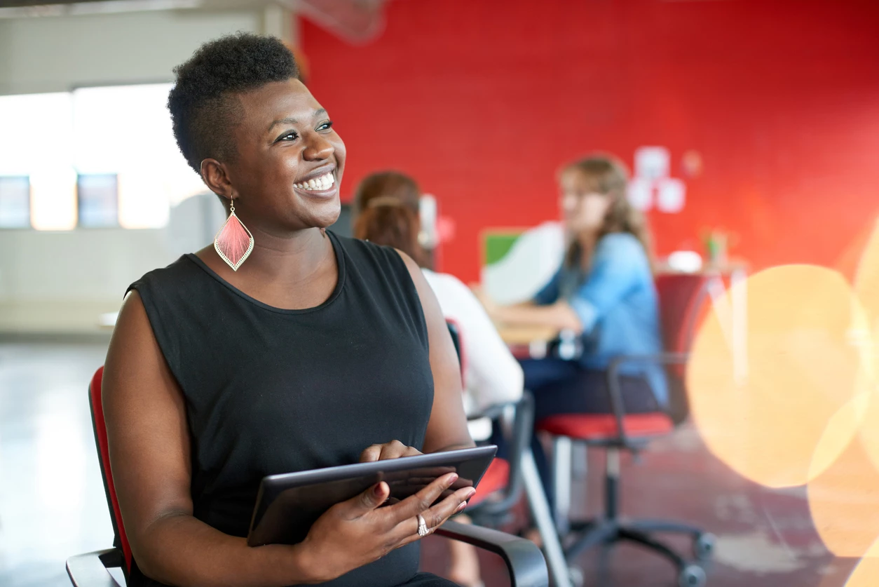 Black professional woman using a tablet in a creative office