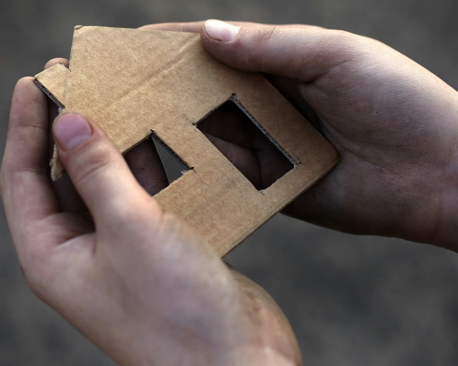 Boy holding cardboard house cutout