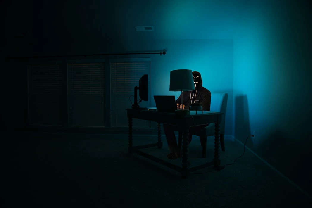 Hacker at a laptop in the dark