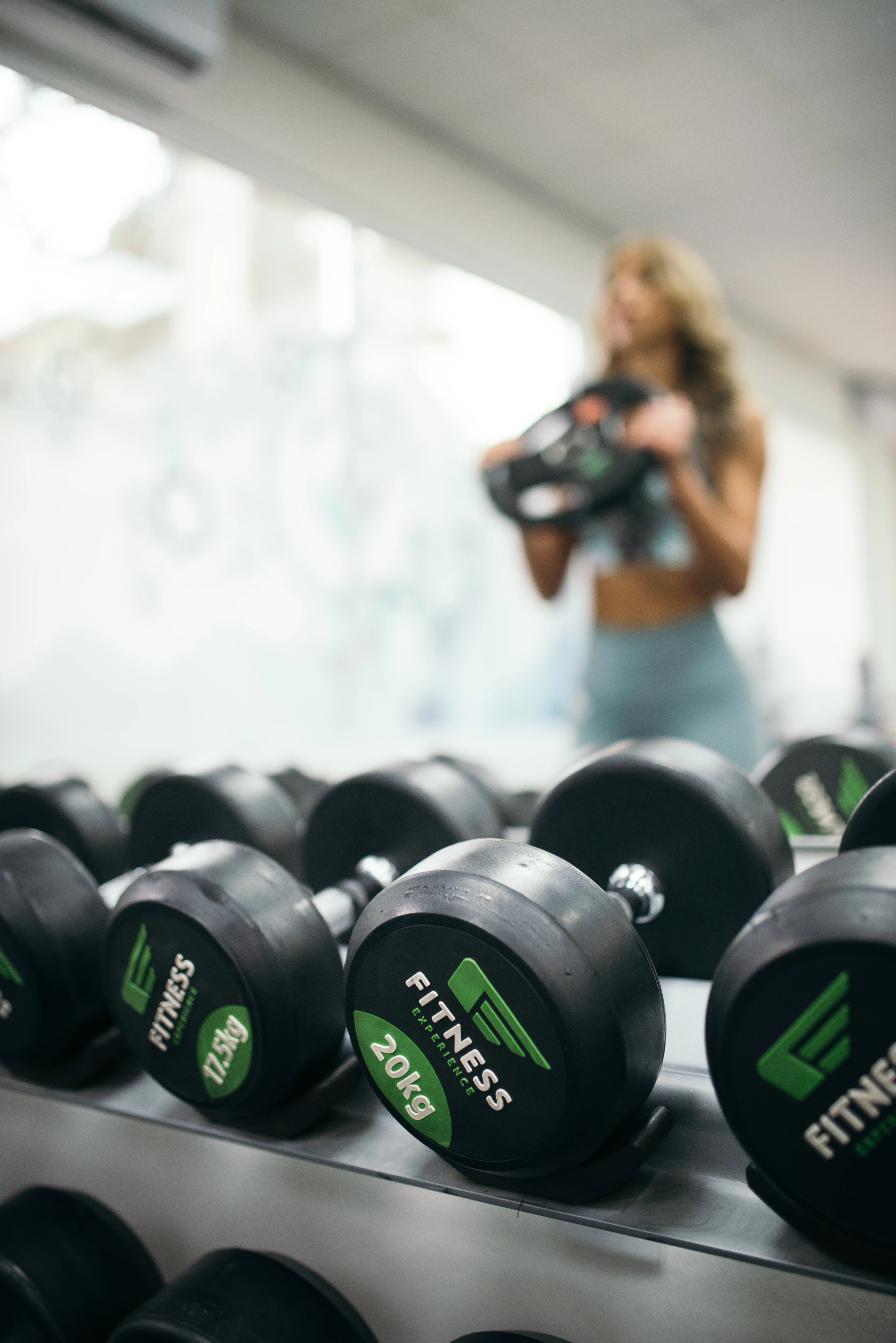 Group of weight in the gym with girl in the mirror.