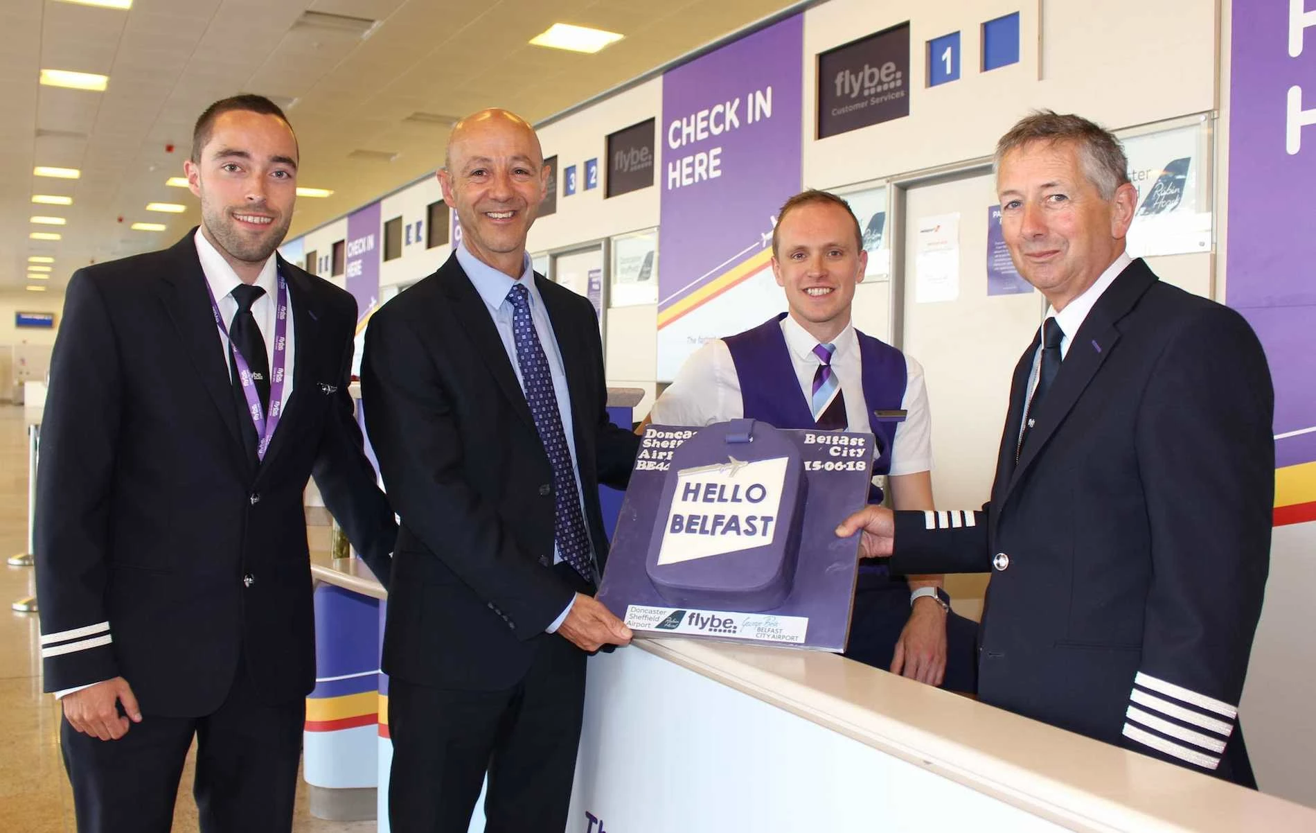 EO Steve Gill (2nd from the left) presents the Flybe Belfast Flight Crew with their inaugural flight celebration cake.