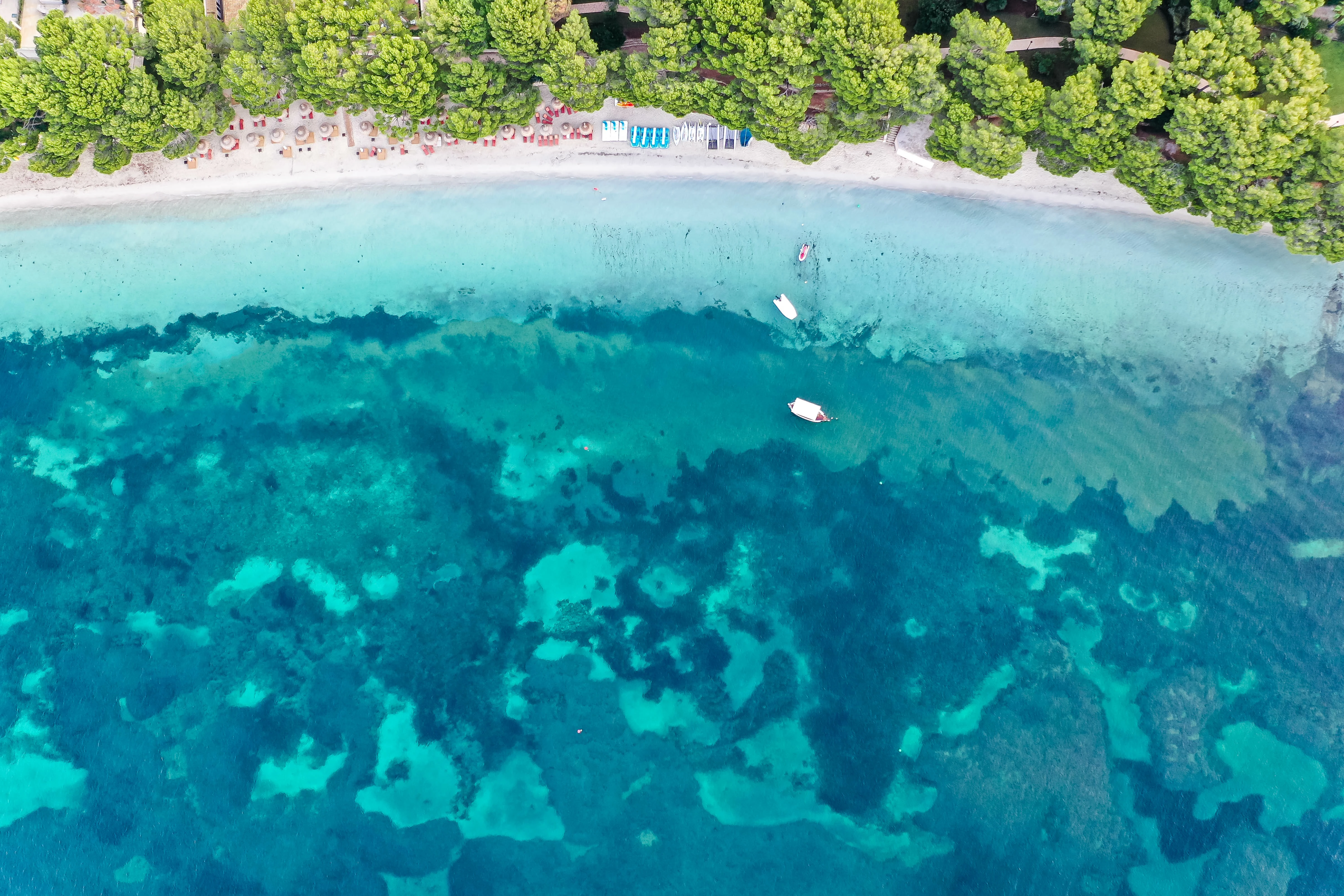 Luftaufnahme: Platja de Formentor auf Mallorca. Strand mit Kiefern, türkisem Wasser und drei Booten