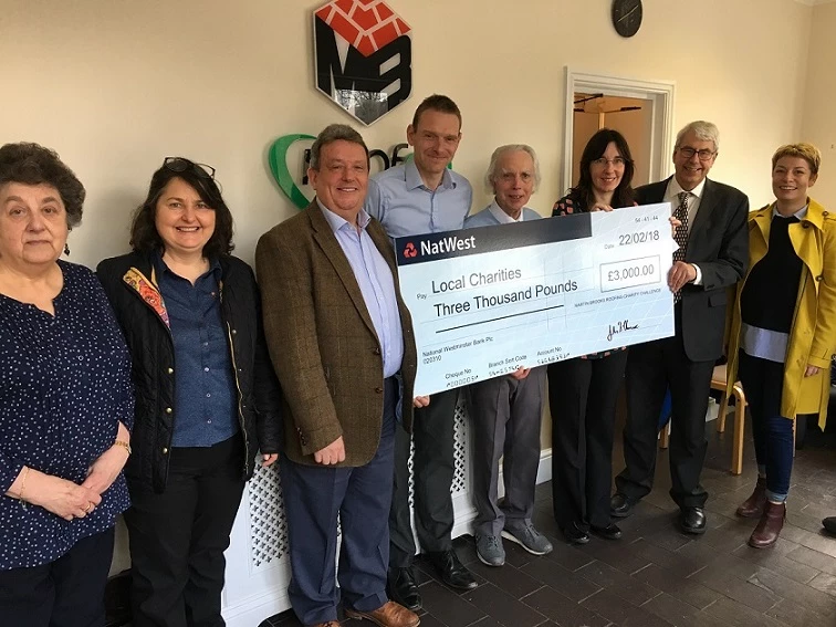 Martin-Brooks directors, John Elmore and Nick Brooks (third and fourth left), present local charity representatives with the proceeds from their latest fundraising efforts. 