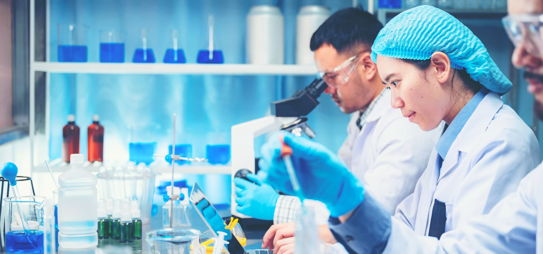 Scientists working in a lab with microscopes.