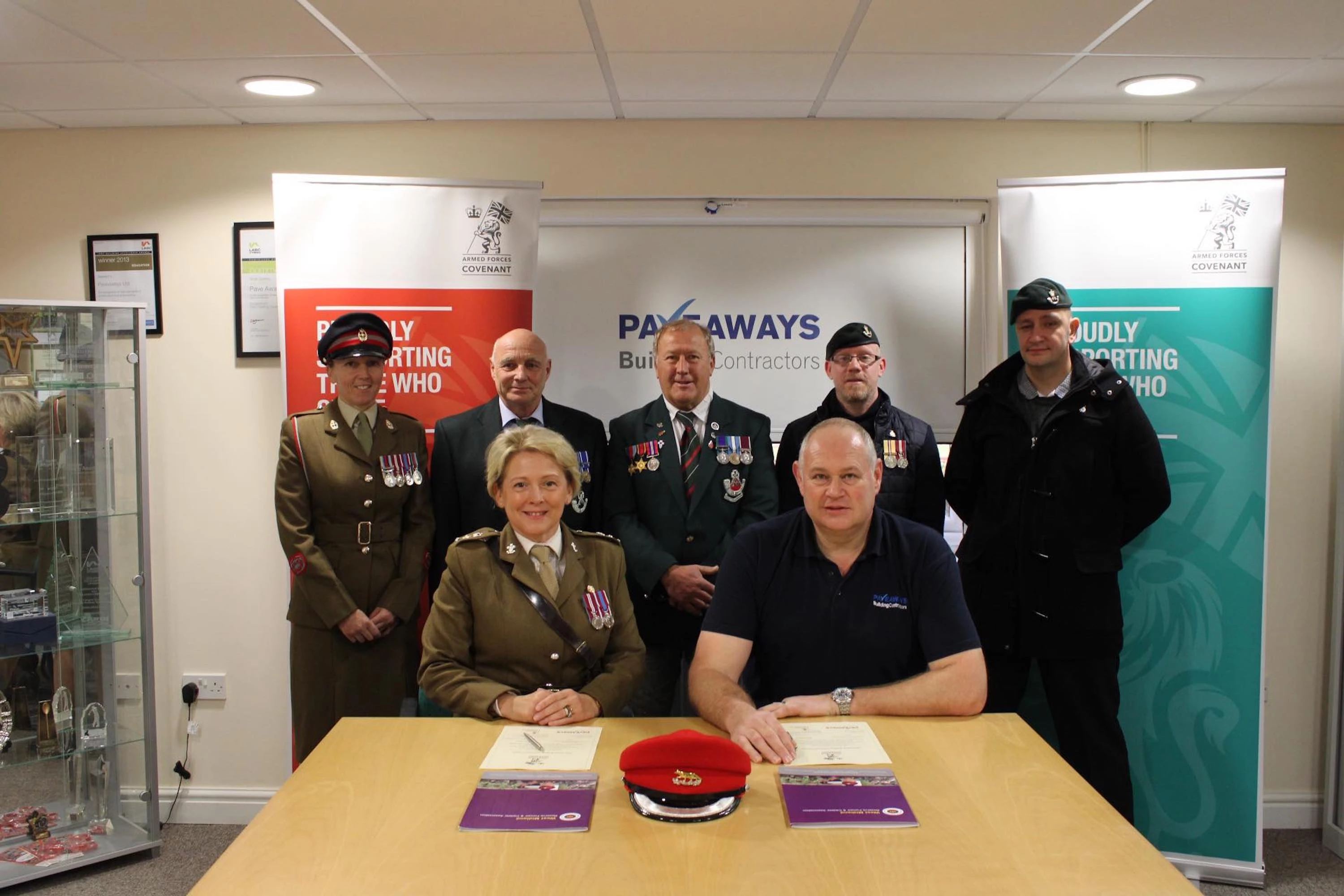 Lt Col Samantha Brettell and Steven Owen sign the covenant watched by Armed Forces lead at The Robert Jones and Agnes Hunt Hospital Rebecca Warren and former military personnel John Friend, Ray Green, Jed Stone & Russ Hale