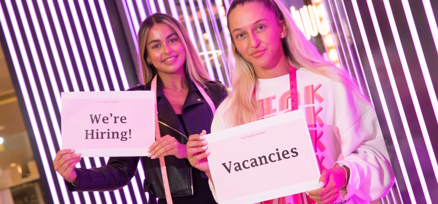 Young people holding up signs reading 'Vacancies' and 'We're Hiring' at Gateshead Metrocentre.